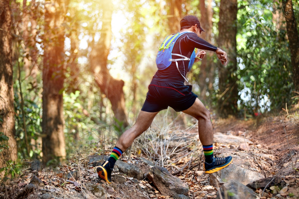 man running through forrest_shutterstock_1695464083