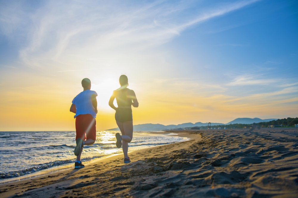 man woman running on beach_shutterstock_1096260575.jpg